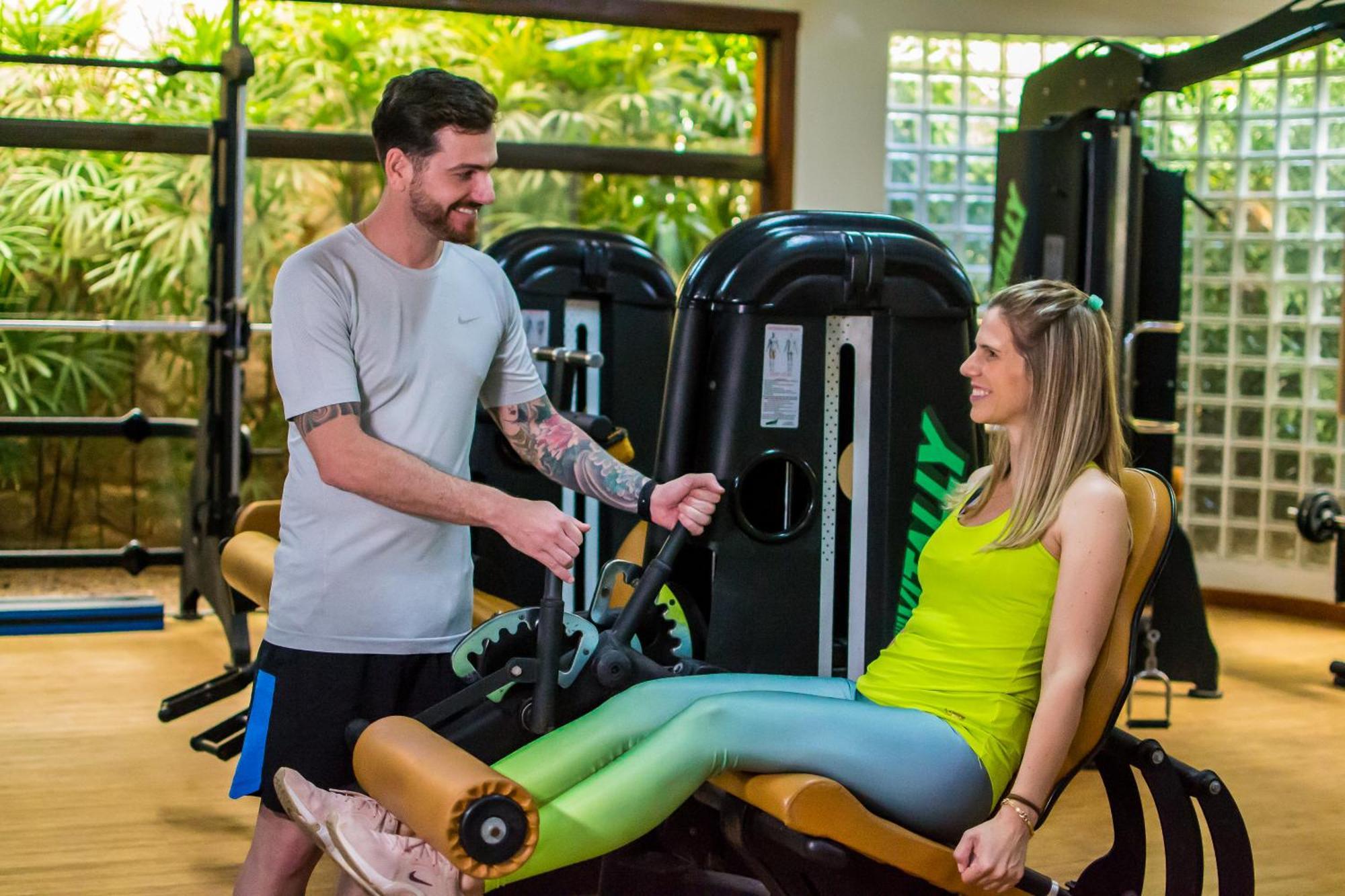 Blue Tree Thermas De Lins Resort Luaran gambar Personal trainer assisting a woman on a leg press machine